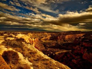 view of a canyon and partly cloudy sky in red and blue tones
